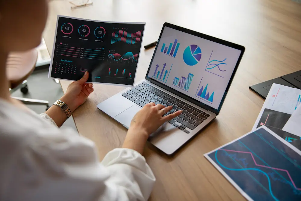 Imagem mostrando pessoa com relatórios de IA, destacando eficiência em análise de dados, visualização interativa e previsões precisas para estratégias de negócios.