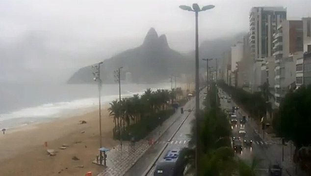 foto da orla de Ipanema em dia de chuva com o morro Dois Irmãos ao fundo. (Fonte: Reprodução Painel Global)